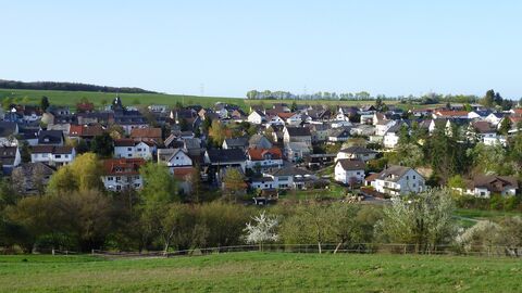 Gemeinde Bechtheim Bild der Gemeinde Bechtheim fotografiert unter einem hellblauen Himmel, im Vordergrund sieht man grüne Wiesen und Bäume.