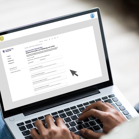Ausfüllen Online-Formular Person füllt auf dem Laptop ein Online-Formular aus.